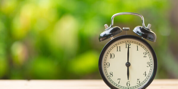 clock on wood table in the green garden time at 6 o'clock
