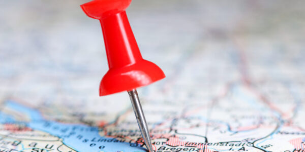 Pinpointed location of a city, country on a map. Red pushpin highlighting a location.
